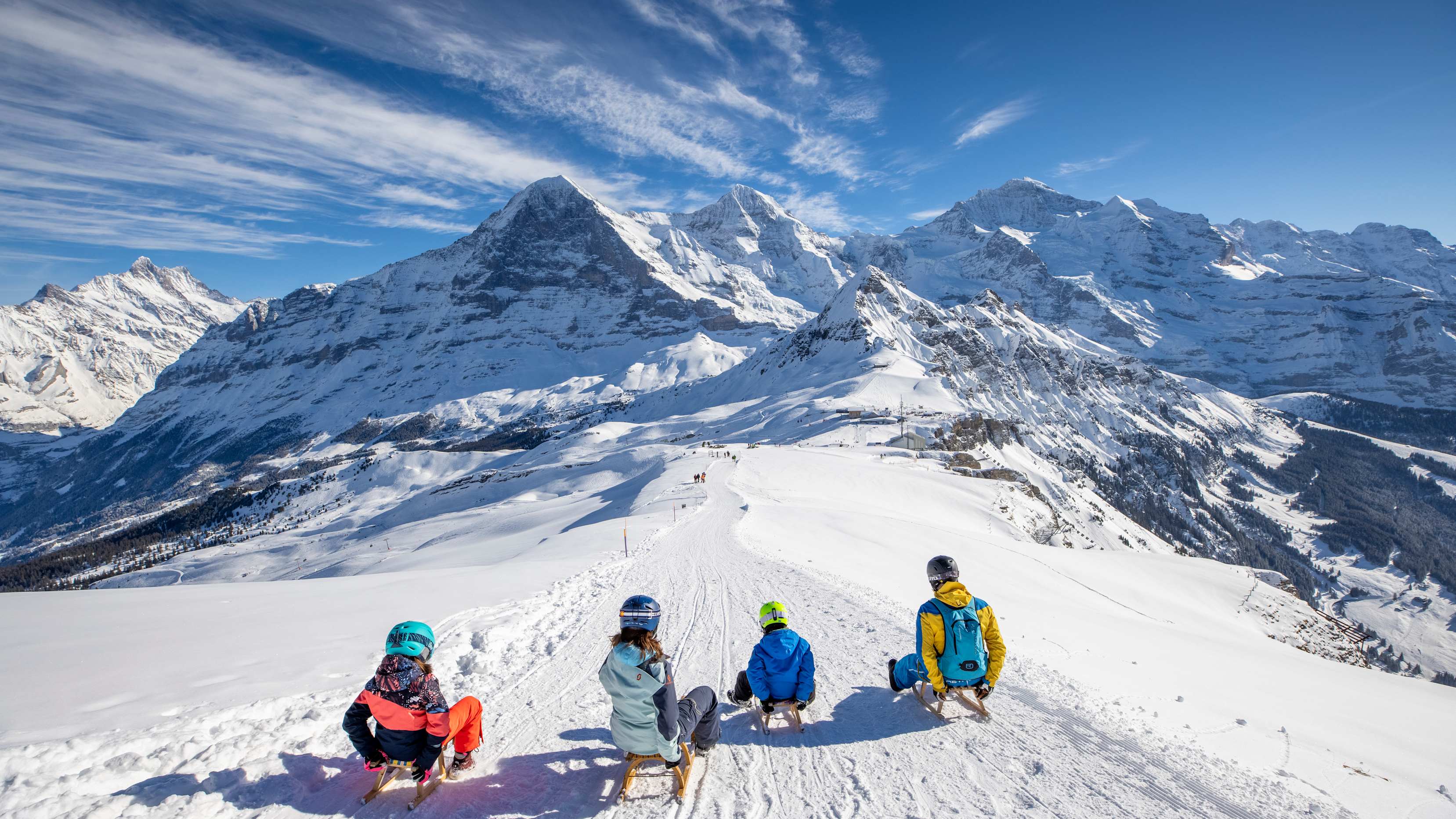 Maennlichen Familie Schlitteln nebeneinander Eiger Moench Jungfrau